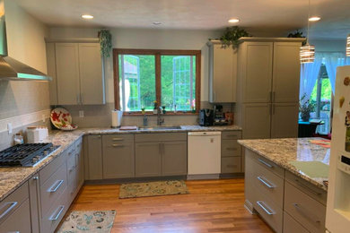 Open concept kitchen - large modern u-shaped light wood floor and brown floor open concept kitchen idea in Chicago with an undermount sink, shaker cabinets, gray cabinets, granite countertops, gray backsplash, subway tile backsplash, white appliances, a peninsula and gray countertops