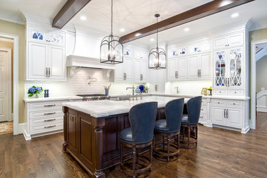 Eat-in kitchen - large traditional l-shaped medium tone wood floor and brown floor eat-in kitchen idea in Atlanta with a farmhouse sink, beaded inset cabinets, white cabinets, marble countertops, white backsplash, paneled appliances, an island and white countertops