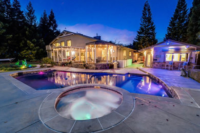 Example of a large mountain style beige two-story stone exterior home design in San Francisco with a shingle roof