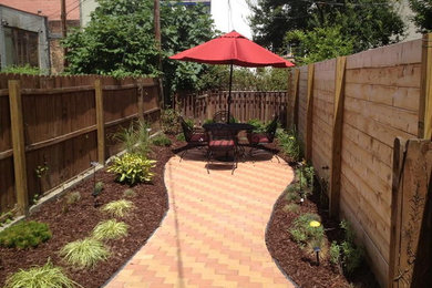 This is an example of a mid-sized transitional backyard partial sun formal garden for spring in New York with a garden path and brick pavers.