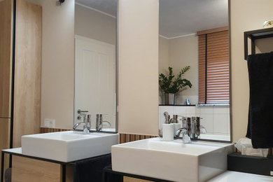 Modernes Badezimmer mit bodengleicher Dusche, weißen Fliesen, beiger Wandfarbe, Aufsatzwaschbecken, Falttür-Duschabtrennung, weißer Waschtischplatte, Doppelwaschbecken, schwebendem Waschtisch und Wandpaneelen in Frankfurt am Main