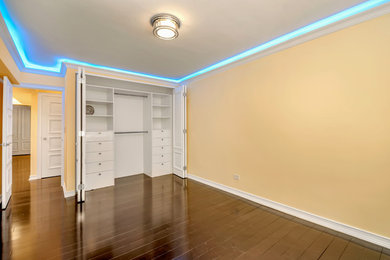 Mid-sized trendy guest dark wood floor bedroom photo in New York with beige walls and no fireplace