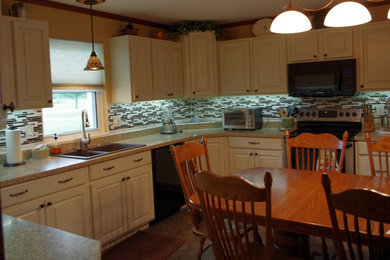 Photo of a mid-sized traditional u-shaped eat-in kitchen in St Louis with a drop-in sink, raised-panel cabinets, white cabinets, laminate benchtops and multi-coloured splashback.