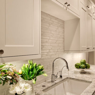Geräumige Moderne Küche mit Vorratsschrank, Unterbauwaschbecken, Schrankfronten im Shaker-Stil, weißen Schränken, Granit-Arbeitsplatte, Küchenrückwand in Weiß, Rückwand aus Glasfliesen und Kücheninsel in Seattle