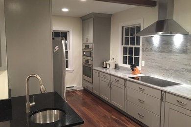 Eat-in kitchen - large transitional l-shaped dark wood floor eat-in kitchen idea in Baltimore with an undermount sink, shaker cabinets, white cabinets, marble countertops, gray backsplash, stone slab backsplash, stainless steel appliances and an island