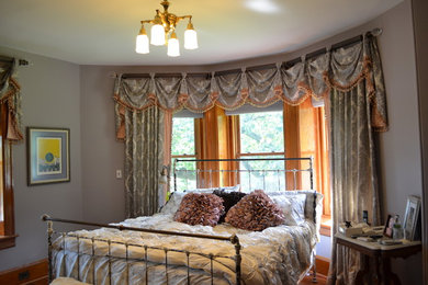 This is an example of a mid-sized traditional master bedroom in New York with grey walls, medium hardwood floors and no fireplace.