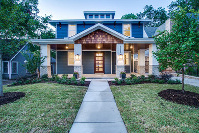 Photo of a mid-sized arts and crafts two-storey blue house exterior in Dallas with wood siding.