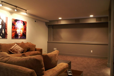 This is an example of a mid-sized contemporary enclosed home theatre in Seattle with brown walls, carpet, a projector screen and brown floor.