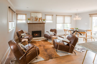 Photo of a mid-sized transitional open concept living room in Boston with grey walls, medium hardwood floors, a standard fireplace, a tile fireplace surround, no tv and brown floor.