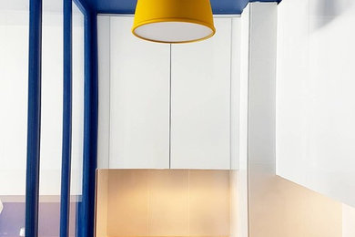 Réalisation d'une petite cuisine parallèle design fermée avec un évier 1 bac, un placard à porte affleurante, des portes de placard blanches, un plan de travail en bois, une crédence blanche, un électroménager en acier inoxydable et îlot.