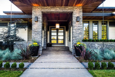 Example of a large transitional concrete floor entryway design in Vancouver with beige walls and a black front door