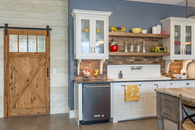Large farmhouse l-shaped porcelain tile and brown floor eat-in kitchen photo in Other with a drop-in sink, raised-panel cabinets, white cabinets, marble countertops, brown backsplash, stone tile backsplash, stainless steel appliances and an island