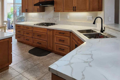 Inspiration for a contemporary kitchen remodel in San Diego with shaker cabinets, brown cabinets, quartz countertops and white countertops