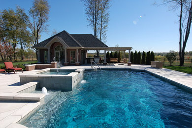 Mid-sized trendy backyard concrete paver and custom-shaped pool house photo in Other
