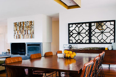 Contemporary open plan dining in Sydney with white walls, medium hardwood floors and a standard fireplace.