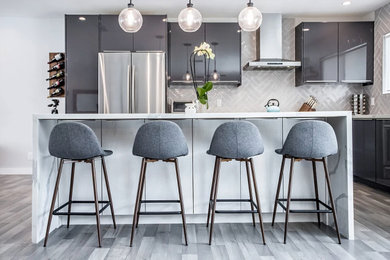 Eat-in kitchen - large contemporary u-shaped porcelain tile and gray floor eat-in kitchen idea in Los Angeles with an undermount sink, flat-panel cabinets, gray cabinets, quartzite countertops, gray backsplash, ceramic backsplash, stainless steel appliances, an island and white countertops