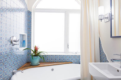 This is an example of a small mediterranean master bathroom in San Francisco with a freestanding tub, a shower/bathtub combo, ceramic tile, white walls, mosaic tile floors, a wall-mount sink, a shower curtain, white benchtops, blue tile and turquoise floor.
