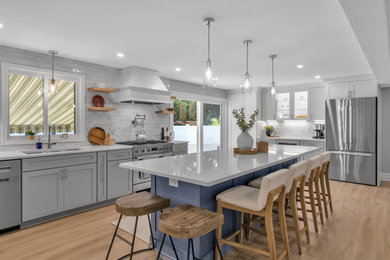 Eat-in kitchen - contemporary l-shaped light wood floor eat-in kitchen idea in New York with shaker cabinets, porcelain backsplash, an island and white countertops