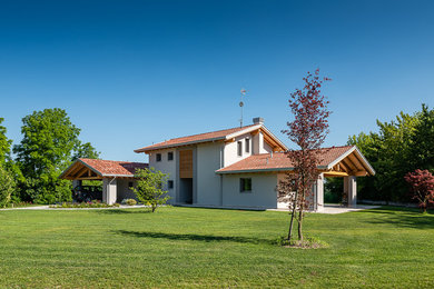 Idee per la villa grande grigia country a due piani con rivestimento in stucco, tetto a capanna e copertura in tegole