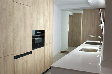Imagen de cocina blanca y madera moderna abierta sin isla con fregadero de un seno y encimeras blancas
