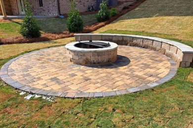 This is an example of a mid-sized craftsman full sun backyard brick and wood fence landscaping in Other with a fire pit for summer.