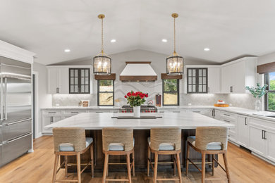 Kitchen - large transitional brown floor and vaulted ceiling kitchen idea in San Diego with quartz countertops, white backsplash, ceramic backsplash, stainless steel appliances, an island and white countertops