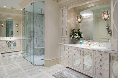 Inspiration for a large transitional master bathroom in Miami with recessed-panel cabinets, white cabinets, an alcove shower, subway tile, white walls, an undermount sink, marble benchtops, marble floors, white floor and a hinged shower door.