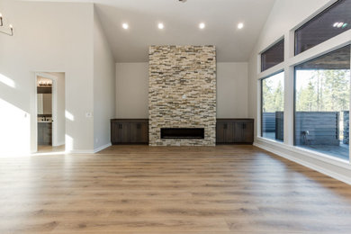 Inspiration for a rustic open concept vaulted ceiling living room remodel in Other with a standard fireplace, a brick fireplace and a wall-mounted tv