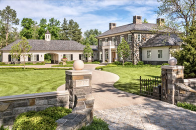 Example of a gray two-story stone and clapboard house exterior design in Denver with a hip roof and a gray roof