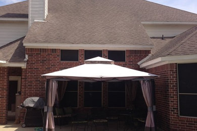 Exemple d'une terrasse arrière chic de taille moyenne avec du béton estampé et une extension de toiture.