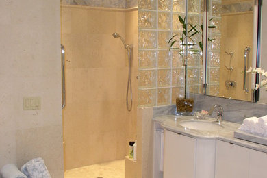 Example of a mid-sized island style master beige tile and travertine tile travertine floor and beige floor bathroom design in Miami with flat-panel cabinets, white cabinets, a hot tub, beige walls, an undermount sink, quartzite countertops and gray countertops