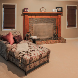 Foto di un'ampia camera matrimoniale etnica con pareti marroni, moquette, camino classico e cornice del camino piastrellata