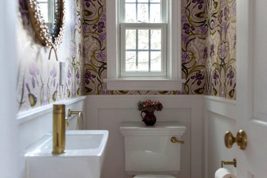Example of a small transitional ceramic tile and wainscoting powder room design in New York with white cabinets, a one-piece toilet, a wall-mount sink and a floating vanity
