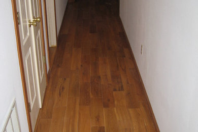 Inspiration for a mid-sized eclectic medium tone wood floor and brown floor hallway remodel in Other with white walls