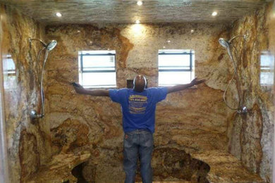 Example of a huge master brown tile and stone slab travertine floor, beige floor and double-sink bathroom design in Houston with shaker cabinets, dark wood cabinets, a two-piece toilet, white walls, a trough sink, granite countertops, a hinged shower door, gray countertops and a built-in vanity