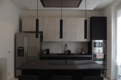 Idee per una cucina minimal di medie dimensioni con lavello da incasso, ante lisce, ante blu, top in granito, paraspruzzi a effetto metallico, elettrodomestici in acciaio inossidabile, pavimento in gres porcellanato, penisola, pavimento grigio, top nero e soffitto ribassato
