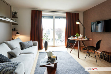 Kleines, Offenes Retro Wohnzimmer mit brauner Wandfarbe, hellem Holzboden, TV-Wand und beigem Boden in München