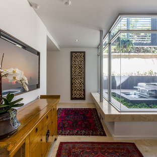 Foto de distribuidor ecléctico, grande, con paredes blancas, suelo de piedra caliza, puerta pivotante, puerta de madera en tonos medios y suelo beige