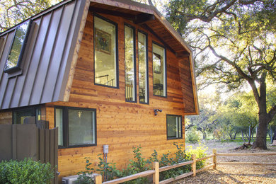 Example of a trendy wood exterior home design in Los Angeles with a gambrel roof