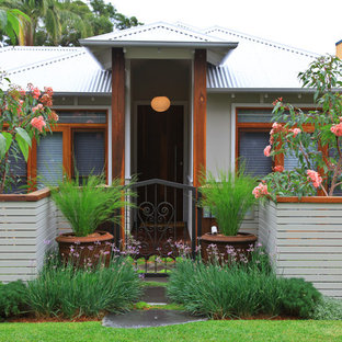 Design ideas for a small tropical one-storey exterior in Sydney with a hip roof.