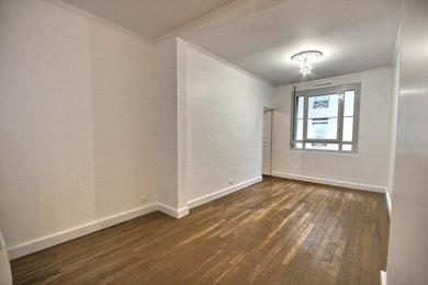 Mittelgroßes, Abgetrenntes Klassisches Wohnzimmer mit weißer Wandfarbe und braunem Holzboden in Paris