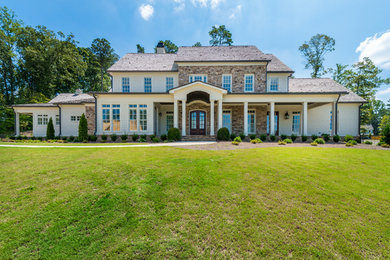 Inspiration for a large cottage beige two-story mixed siding house exterior remodel in Atlanta with a gambrel roof and a shingle roof