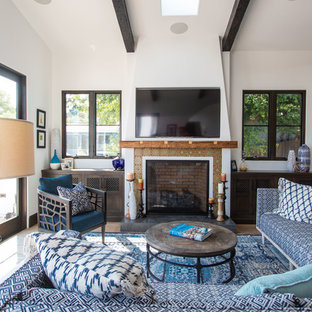 Imagen de salón mediterráneo con paredes blancas, suelo de madera en tonos medios, chimenea de doble cara, marco de chimenea de baldosas y/o azulejos, televisor colgado en la pared y suelo marrón