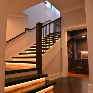 Foto de escalera en U, extra grande, con escalones de madera y contrahuellas de vidrio