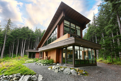Large contemporary brown three-story wood exterior home idea in Other with a metal roof