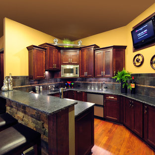 シアトルの中サイズのコンテンポラリースタイルのおしゃれなウェットバー (無垢フローリング、アンダーカウンターシンク、落し込みパネル扉のキャビネット、濃色木目調キャビネット、御影石カウンター、グレーのキッチンパネル、磁器タイルのキッチンパネル、茶色い床) の写真