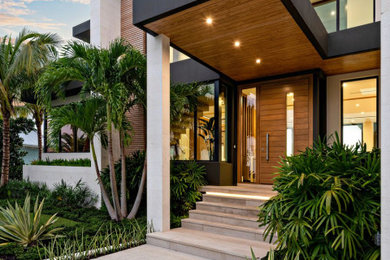 Design ideas for a mid-sized contemporary two-storey house exterior in Miami with a flat roof.