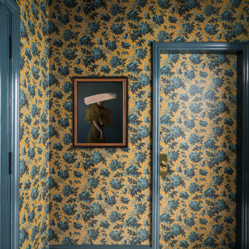 Foyer with Dark Yellow and Teal Floral Wallpaper, Marble Floor, and Brass Accent