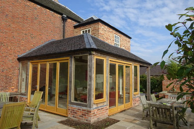 Inspiration for a medium sized and brown classic brick detached house in Other with three floors, a half-hip roof and a shingle roof.