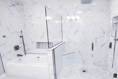 Inspiration for a mid-sized modern master multicolored tile and marble tile light wood floor and white floor bathroom remodel in Seattle with a one-piece toilet, white walls, marble countertops, a hinged shower door and white countertops